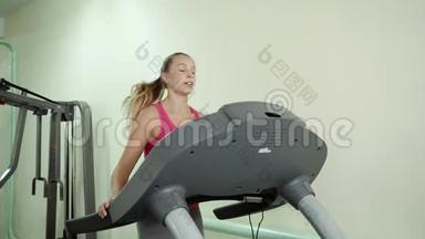 漂亮的白种人女孩在运动健身房的跑步机上跑步。
